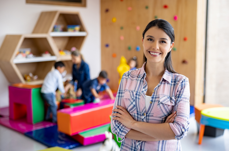 business plan for opening a childcare center Childcare provider smiling with children playing in the background