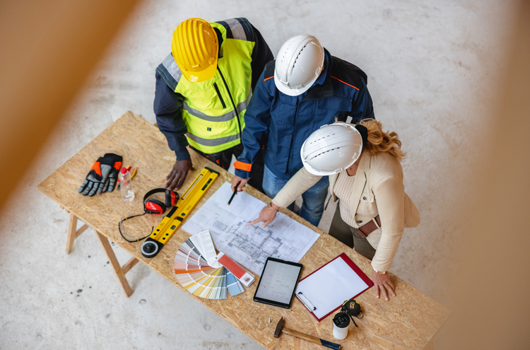 Top view of female architect talking with construction engineers