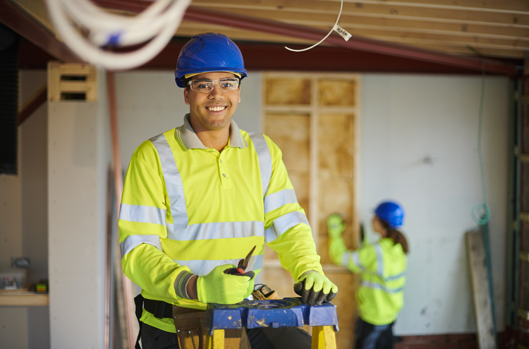 Smiling male electrician on ladder smiling