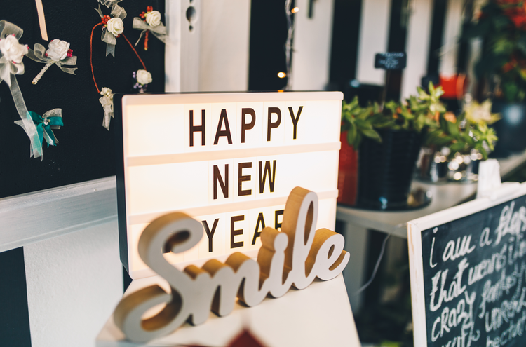 Illuminated happy new year sign and a smile sign at a flower shop during holidays.