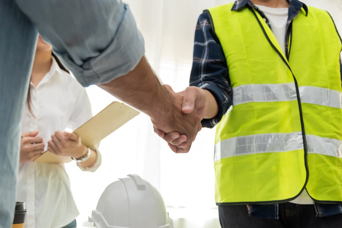 group of architect and engineer construction worker partner handshake in meeting room office at construction site